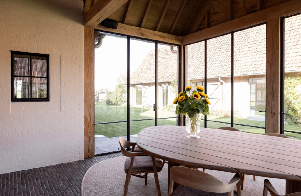 Eetruimte met stalen ramen in een bijgebouw, hoeve in Knokke. Bovijn&Partners, fotografie Joachim van Belleghem